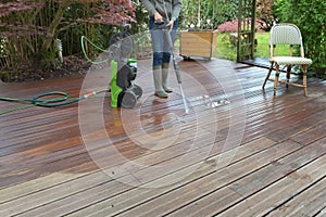 Woman washing terrace with a water high pressure