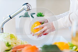 Woman washing vegetables.