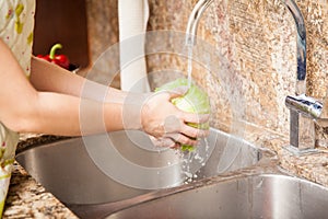 Woman washing vegetables