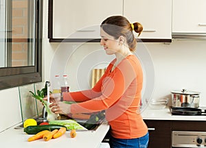 Woman washing vegetables in kitchen