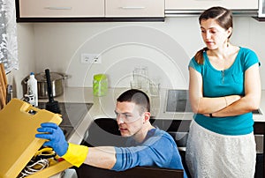 Woman watching as plumber working