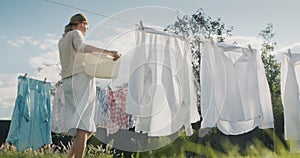 Woman watching bed linens dry in the backyard of the house