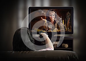 Woman watching esoteric TV channel on a couch