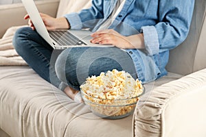 Woman watching film on sofa and eat popcorn Food for watching films