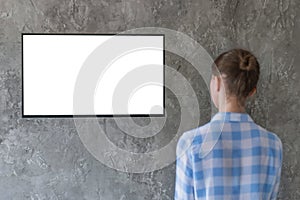 Woman watching flat smart led TV with white blank screen - mockup concept