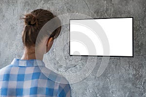 Woman watching flat smart led TV with white blank screen - mockup concept