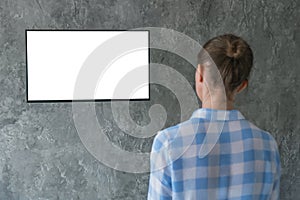 Woman watching flat smart led TV with white blank screen - mockup concept