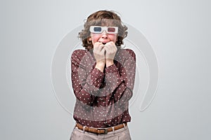 Woman watching horror film in vintage stereo 3d glasses being afraid