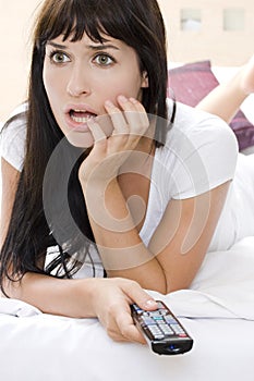 Woman watching a horror movie in tv alone