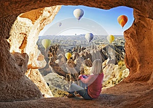 Woman watching like colorful hot air balloons flying over the valley at Cappadocia photo