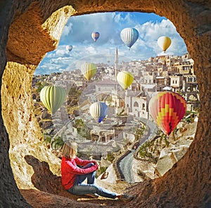 Woman watching like colorful hot air balloons flying over the valley at Cappadocia photo