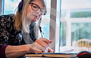 Woman watching a live webinar on her laptop,wearing headphones photo