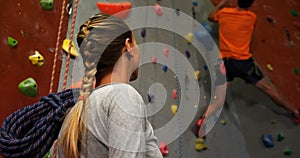 Woman watching a man climbing artificial wall 4k