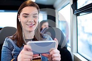 Woman Watching Movie On Mobile Phone During Journey To Work