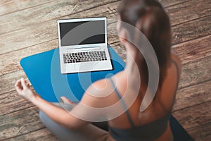 Woman watching online yoga lessons