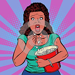 Woman watching a scary movie and eating popcorn