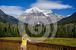 Woman watching the snowy peak of Mount Robson, the highest peak in the Canadian Rockies in Mt. Robson Provincial Park