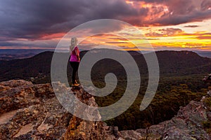 Woman watching storm clouds over Blue Mountains at sunset photo