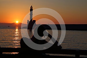 Woman watching sunset behind the lighthouse