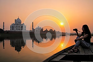 Woman watching sunset over Taj Mahal from a boat, Agra, India