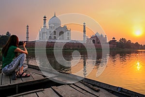 Woman watching sunset over Taj Mahal from a boat, Agra, India