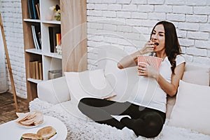 Pregnant Woman Watching a TV and Eating