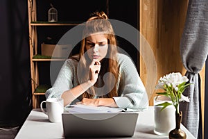 Woman watching webinar on laptop in cafe