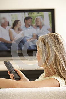 Woman Watching Widescreen TV At Home