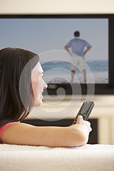 Woman Watching Widescreen TV At Home