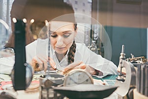 Woman watchmaker working diligently on repairing a watch