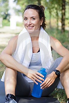 woman with water bottle taking rest after exercising photo