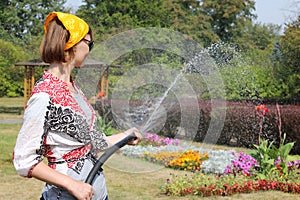 Una mujer regando flores 