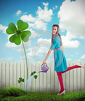 Woman watering a four leaf clover