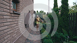 woman watering plants in the yard