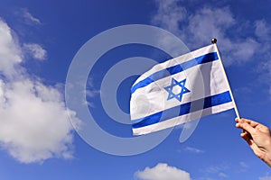 Woman wave flag of Israel against blue sky photo