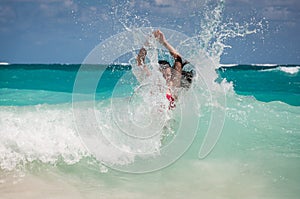 A woman and a wave splash in the Caribbean sea