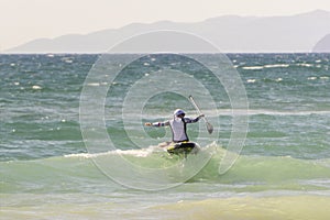 Woman on the waves in the sea swims, is engaged in a standing oar