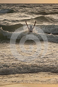 Woman in the waves on sunset