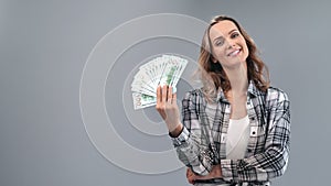 Woman waving fan of cash money dollar enjoying lottery win isolated. Shot with RED camera in 4K