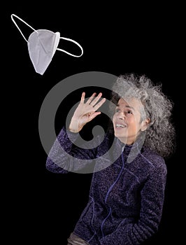 Woman waving goodbye to FFP2 face mask Black background