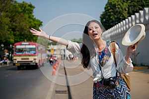 Woman waving her hands to get on the tuk-tuk