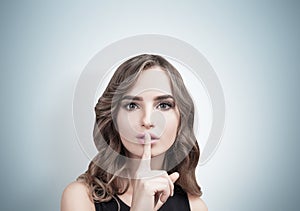 Woman with wavy hair making hush sign