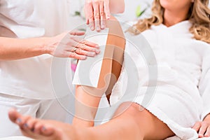 Woman at waxing hair removal in beauty parlor photo