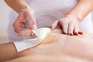 Woman Waxing Man`s Chest With Wax Strip