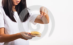 Woman weak hair her hold hairbrush with damaged long loss hair in the comb brush she pulls loss hair from brush