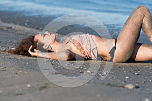 Woman wear bikini, lying on the beach