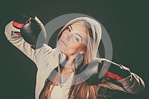 Woman wear boxer gloves with arms in air.