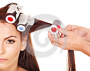 Woman wear hair curlers on head.