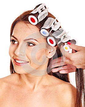 Woman wear hair curlers on head.