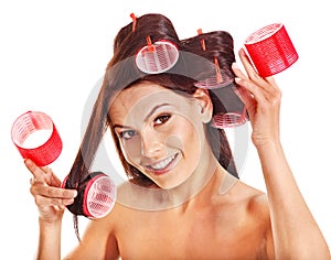 Woman wear hair curlers on head.